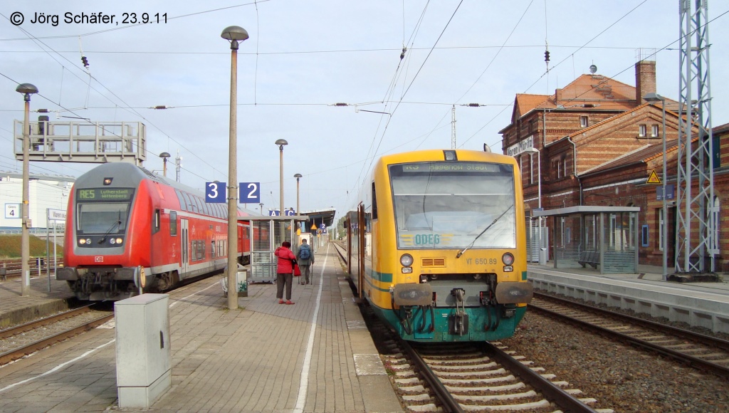 In Waren (Mritz) hat die Mecklenburger Sdbahn Anschluss an die Hauptstrecke Berlin - Rostock. Links der DB-Doppelstock-Steuerwagen des RE nach Wittenberg ber Berlin und rechts der ODEG-VT 650.89 nach Hagenow. (23.9.11)
