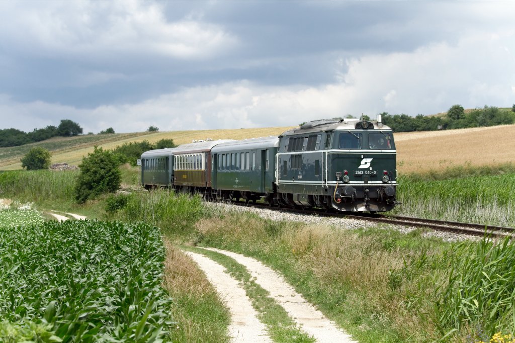 Inmitten des Mollmannsdorfer Berges ist die 2143.40 mit dem Erlebniszug in Richtung Korneuburg unterwegs (25.06.2011)