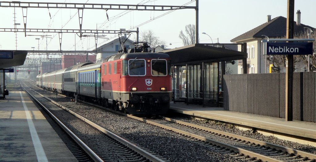 Interessante Verstrkung: Am 23.03.2012 durchfhrt die Re 4/4  11302 mit einem IR nach Basel den Bahnhof Nebikon. Eher selten auf dieser Strecke ist eine Verstrkung mit einem A-Wagen - und der in Form eines EW II.