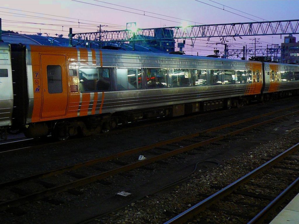 JR Shikoku Serie 8000: Der Wagen 8102 aus dem 5-Wagenzug 8002. Nach Sonnenuntergang, Matsuyama, 17.September 2009.