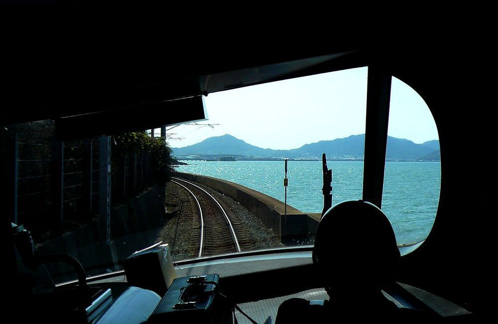 JR Shikoku Serie 8000: Frontwagen 8506 legt sich an der schönen Nordküste der Insel Shikoku in die Kurve. Aufnahme (durch die verglaste Führerstandrückwand) in der Nähe von Takuma, 17.September 2009. 