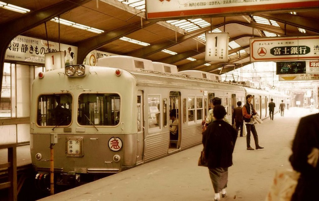 Keiô-Konzern, Inokashira-Linie, Serie 3000: Zug Nr.4 (Endwagen 3754) in Tokyo-Shibuya. Damals sah man noch recht häufig Personen in traditioneller Kleidung mit dem Familienwappen am Rücken, wie hier bei der auf den Zug eilenden Frau. 10.Mai 1973. 