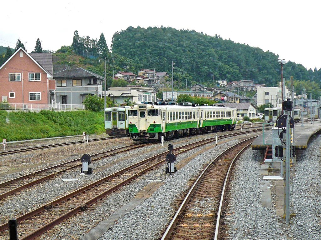 Kesennuma-Linie: Sicher werden die schmucken grün-weissen Züge der Kesennuma-Linie ihr Ziel (die Stadt Kesennuma) nie mehr erreichen. Die Kesennuma-Linie nördlich der Grossstadt Sendai war 72,8 km lang, und sie war die letzte noch von der Staatsbahn gebaute Strecke. Der Nordabschnitt von Kesennuma aus entstand 1956/57, der Südabschnitt 1968, und das 34 km lange Verbindungsstück dazwischen mit vielen Tunnels und prächtigen Brückenbauten 1977. Doch die ganze Nordostküste Japans ist am 11.März 2011 beim Erdbeben (Stärke 9.3) und der anschliessenden Tsunami-Katastrophe fast völlig zerstört worden, mit über 20000 Todesopfern und über 300000 Menschen, die in Notunterkünften leben; Kesennuma selbst (73494 Einwohner) beklagt 1544 Opfer. Das Bild stammt aus glücklicheren Zeiten, mit Zügen der Ôfunato-Linie Bergabschnitt und Küstenabschnitt, und der grün-weissen Komposition der Kesennuma-Linie in der Mitte (Triebwagenpaar KIHA 48 501 und KIHA 48 1511). 9.Juli 2010. 