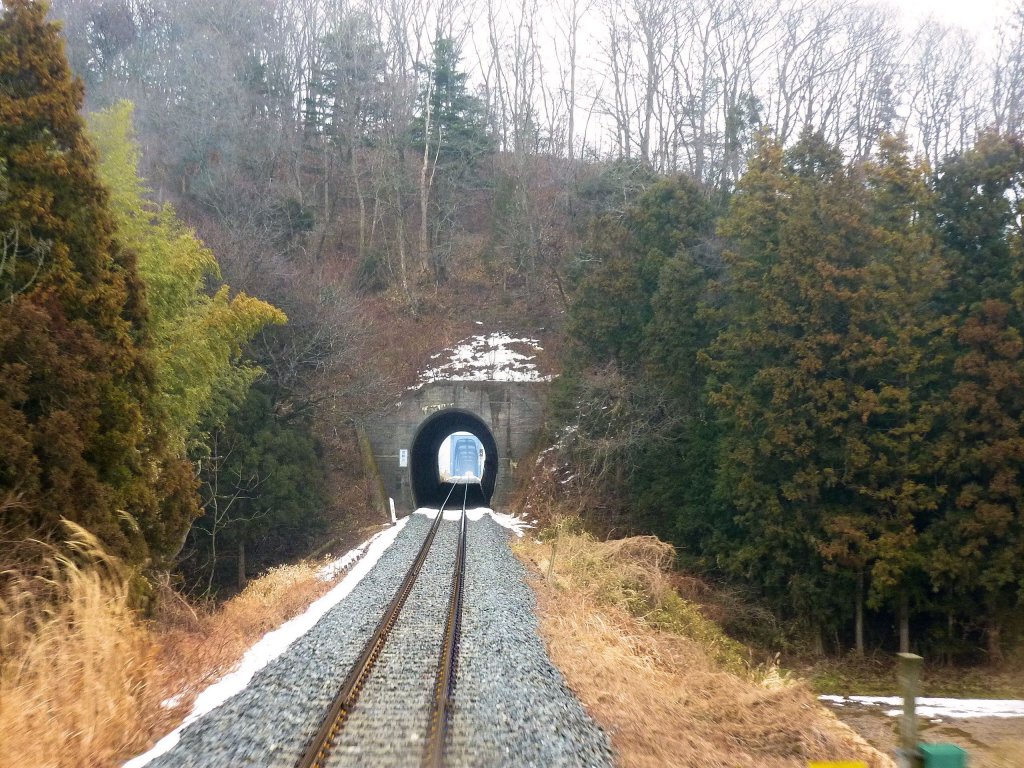 Kesennuma-Linie: So etwa könnte die gesamte Strecke aussehen, wäre sie nicht weitgehend vom Tsunami zerstört; typische relativ gerade Neubaustrecke der späten 1960er/1970er Jahre mit vielen Tunnels und Brücken. Blick aus dem Rückfenster eines Zuges auf den verbliebenen, noch befahrbaren 17,5 km (von 72,8 km) im Inland bei Yanaizu, 15.Februar 2013. 