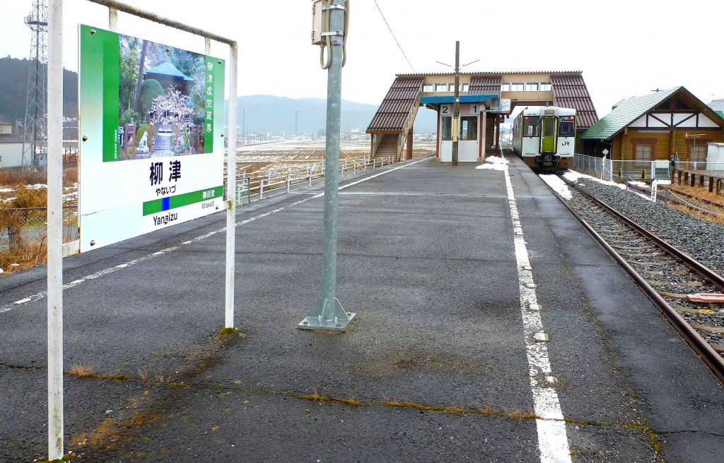Kesennuma-Linie: Von der im Tsunami zerstörten Kesennuma-Linie sind nur noch 17,5 km befahrbar; die Strecke endet abrupt hier im Dorf Yanaizu. Eindrucksvoll sind die Stationstafeln der Kesennuma-Linie, die auf die kulturellen und natürlichen Sehenswürdigkeiten der jeweiligen Ortschaft hinweisen. Die Angabe der folgenden Station auf der Tafel ist abgedeckt, da es keine solche mehr gibt. Anstatt der bunten grünen Doppeltriebwagen KIHA 48 genügt ein einzelner Wagen, hier KIHA 110-125. 15.Februar 2013. 