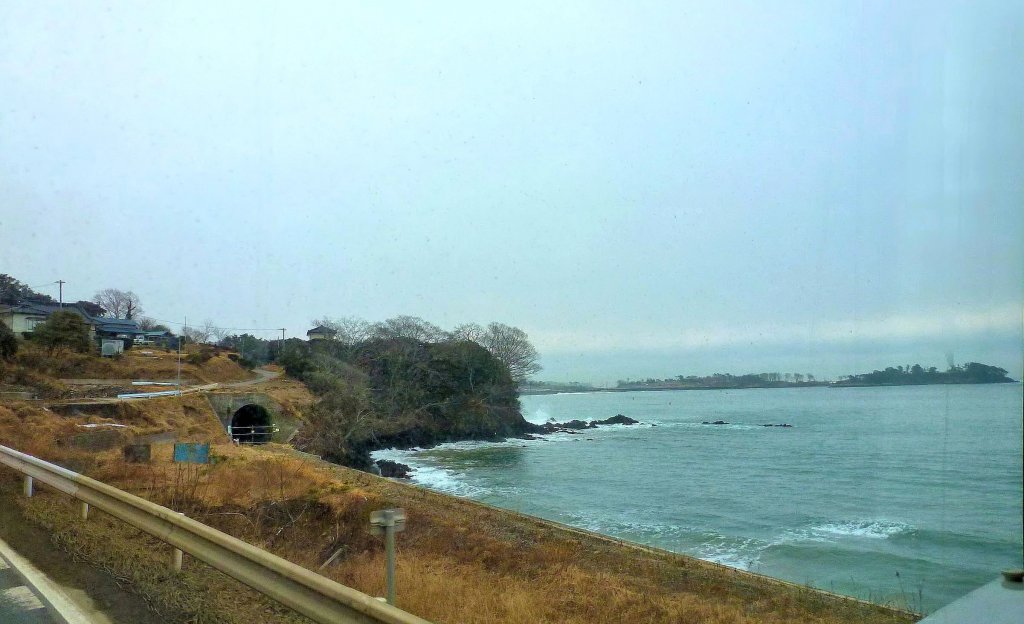 Kesennuma-Linie: Wie schön hoben sich hier in Ôya Kaigan die grün-weissen Züge vor dem Hintergrund des blauens Meers ab! Die Geleise sind jetzt abgebaut. Aufnahme aus dem Schienenersatz-Bus. 15.Februar 2013.  