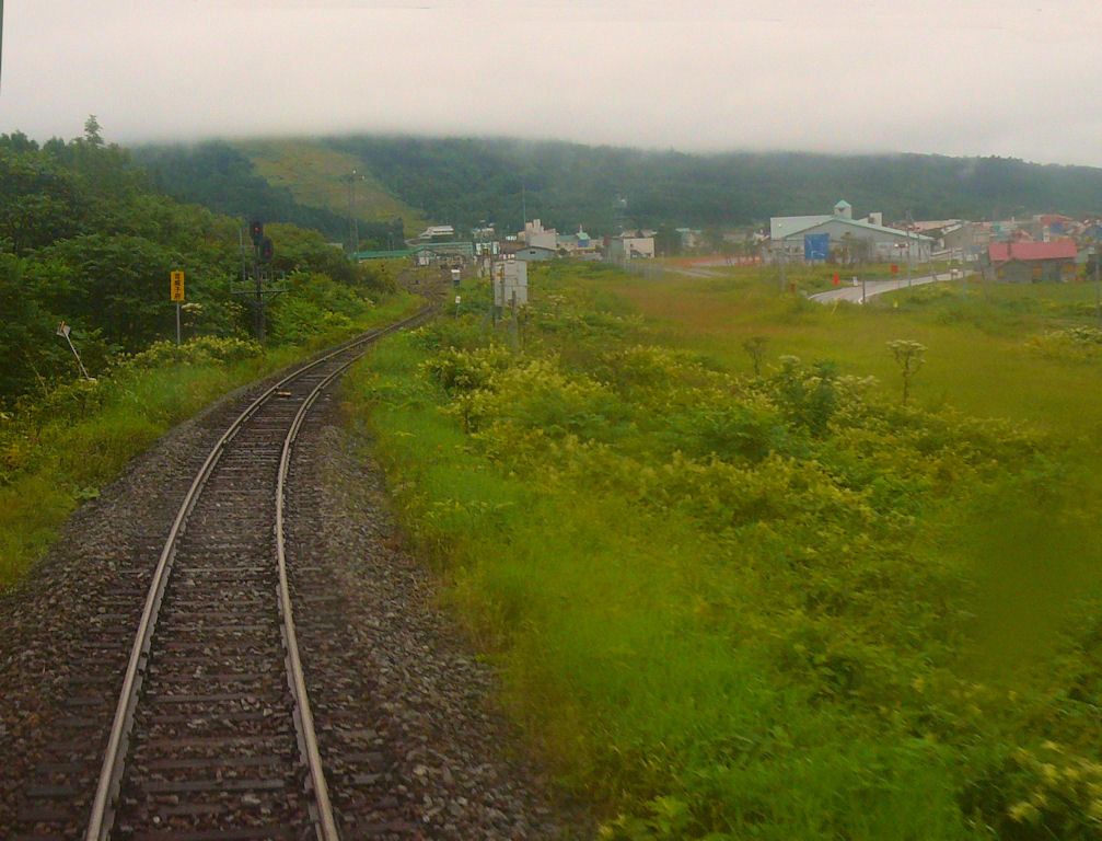KIHA 261: Einfahrt ins einsame Otoineppu, gesehen durch das öffentlich zugänglich gewesene Stirnwandfenster unter dem Hochführerstand von KIHA 261-101, 28.August 2008. Kaum zu glauben, dass hier einst regster Eisenbahnverkehr herrschte; die Hauptlinie von hier nach Nordost-Hokkaido ist stillgelegt, ebenso die Westküstenstrecke, und der intensive Güterverkehr endete 1984. SÔYA-HAUPTLINIE  