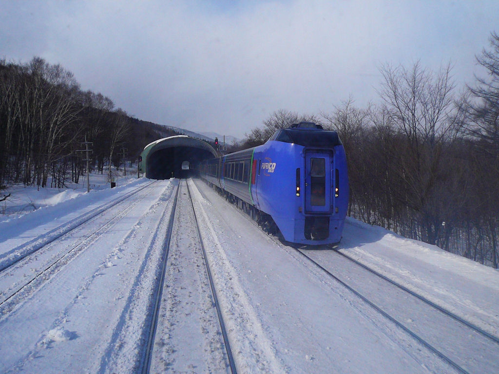 KIHA 283 (キハ283): Ein Zug von Sapporo nach Kushiro braust in Hirouchi vorbei auf dem Abstieg Richtung Ost-Hokkaido. 19.Februar 2009. (Aufnahme durch das damals öffentlich zugängliche Stirnwandfenster unterhalb des Hochführerstands)  SEKISHÔ-LINIE/NEMURO-HAUPTLINIE 