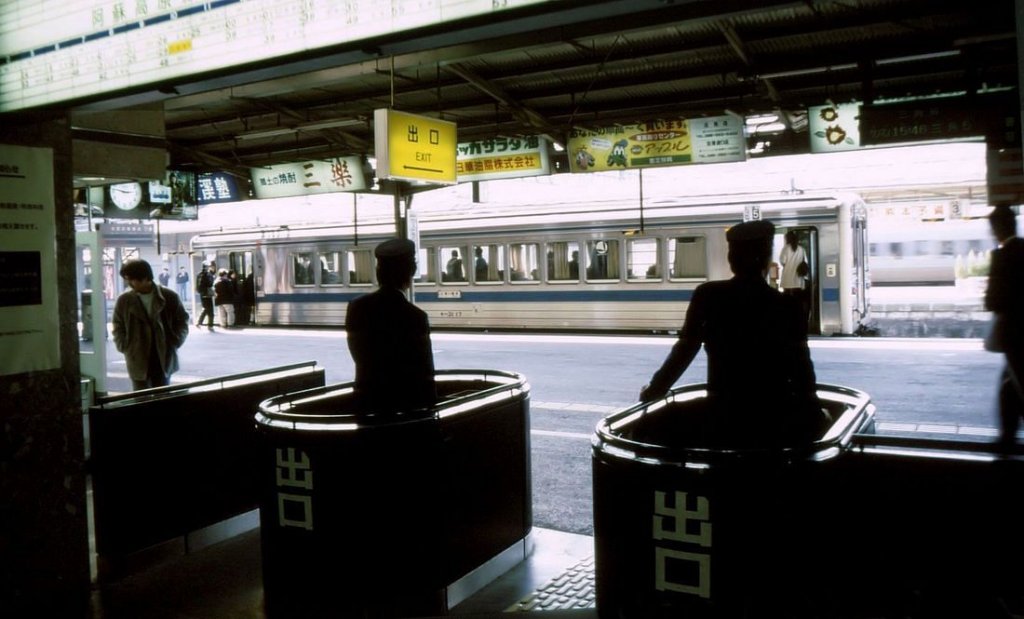 KIHA 31: Blick durch die Bahnsteigsperre von Kumamoto Hauptbahnhof. Dahinter steigen die Fahrgäste in den KIHA 31 17 ein. 31.März 1997. HÔHI-HAUPTLINIE 