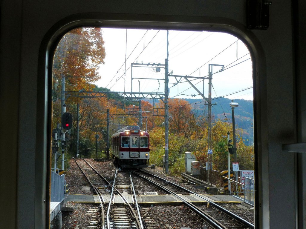 Kintetsu-Konzern, 1067mm-Spurstrecken - die Standardzüge Serie 6000: Der Vierwagenzug mit 6308 an der Spitze kommt in der Ausweiche Ooada unterwegs ins Yoshino-Gebirge entgegen. 2.Dezember 2012. (Aufnahme von der verglasten Führerstandrückwand des entgegenkommenden Zugs aus) 