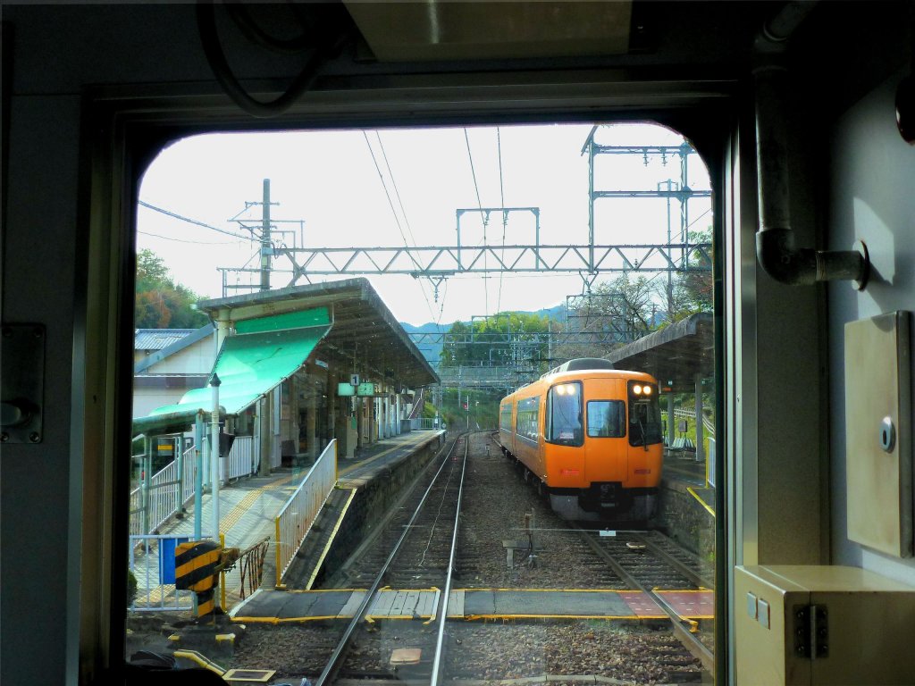 Kintetsu-Konzern, 1067mm-Spurstrecken - zuschlagspflichtige Intercityzüge: Zug 16401 aus der 2.Generation von Intercity-Zügen wartet im ländlichen Tsubosakayama auf die Einfahrt eines Gegenzugs. 2.Dezember 2012. (Aufnahme durch die verglaste Führerstandrückwand des Gegenzugs)