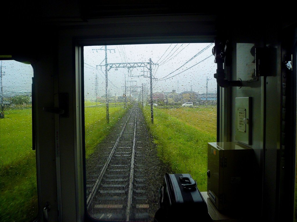 Kintetsu-Konzern, 1067mm-Spurstrecken - Zweiwagenzüge Serie 6400: Auch verregnete Frontfenster einer Lokalbahn können die spätsommerliche Landschaft mit ihren reifen Reisfeldern reizvoll wirken lassen. In Kintetsu-Zug 6425 bei Shakudo, 30.September 2009. (Bild durchs verglaste Führerstandrückwandfenster) 