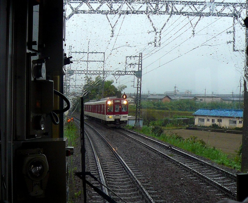 Kintetsu-Konzern, 1067mm-Spurstrecken - Zweiwagenzüge Serie 6400: Am Regentag 30.September 2009 begegnet Zug 6414 in Ukiana. (Aufnahme durch die verglaste Führerstandrückwand eines Gegenzugs)