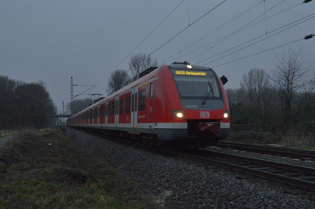 Kleinenbroich, 5.1.2013. Durch die dunkelen Regenwolken kmpft sich ein S5/S8-Zug ber Hagen nach Dortmund. Gleich hlt der 422 533-0 aber erst einmal am Bahnsteig. 