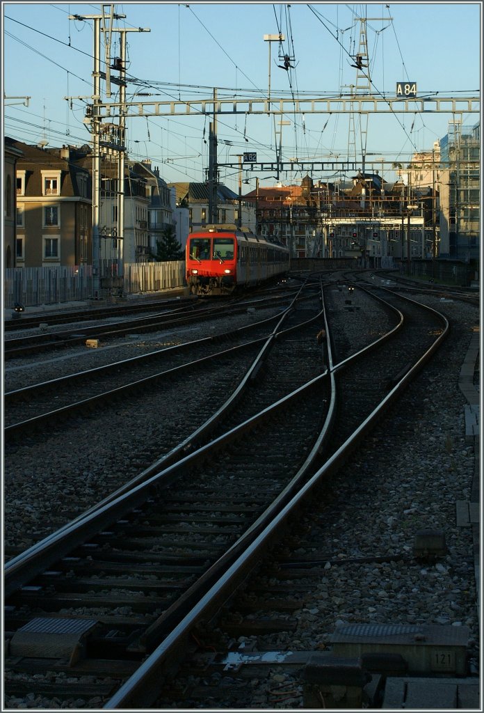 Knapp ber den Gleisen schweben erste flache Morgensonnenstrahlen ber das Gleisvorfeld von Genve und erhellen unbersehbar die Front eines NPZ auf der Fahrt von Lancy Pont Rouge nach Coppet. 
31. August 2010