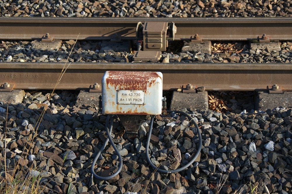 Kontaktfreudig.......

Hier ein Einschaltkontakt eines Bahnbergangs in Lothringen, genau an der Strecke Falck - Bouzonville - Thionville.

Dieser Kontakt schaltet den B bei Tterchen aus Richtung Bouzonville ein. Tterchen ist B 26 an der Strecke und V1 bedeutet dass Gleis 1 den Kontakt auslst. Der Kontakt liegt knapp vor dem B und da stellt man fest, dass nach Auslsung des B der Zug diesen nach ca. 30 - 40 Sekunden passiert. In Deutschland nicht vorstellbar.

Gut zu erkennen auch der besondere Oberbau des Gleises. Hier werden kleine Betonschwellen benutzt, die nur unter den Schienen liegen. Die Betonteile sind unter dem Schotter mit einer Eisenstange verbunden.