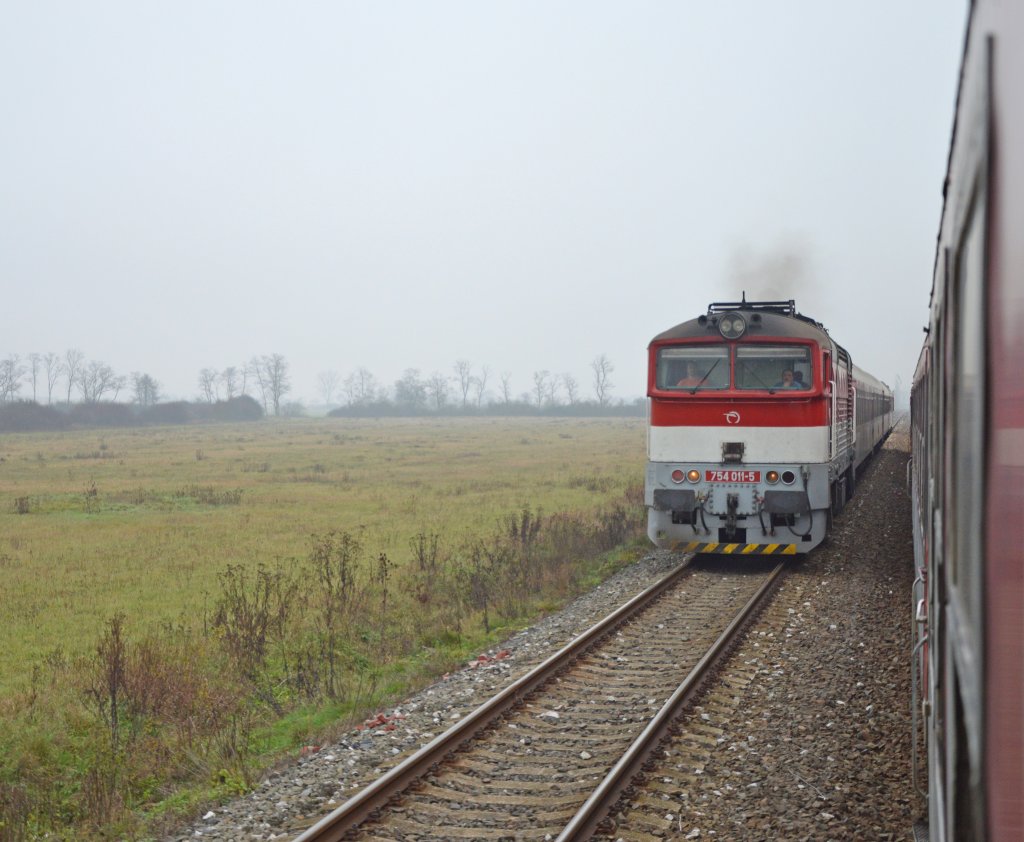 Kreuzung der „Taucherbrille“-Fernzge R 1931 „Bodva“ (rechts) und R 932 „Domica“ mit 754 011-5 auf zweigleisiger Teilabschnitt der Strecke SR 160 Zvolen os. st. – Koice bei Rimavsk Seč (Zug R 1932 mit etwa 15-mintige Versptung, Kreuzung normalweise im Bahnhof Lenartovce. R 932 Preov – Koice – Fiľakovo – Zvolen os. st.; Kurswagen R 932 / 832 Preov – Zvolen – Bratislava hl. st.); 17.11.2012 