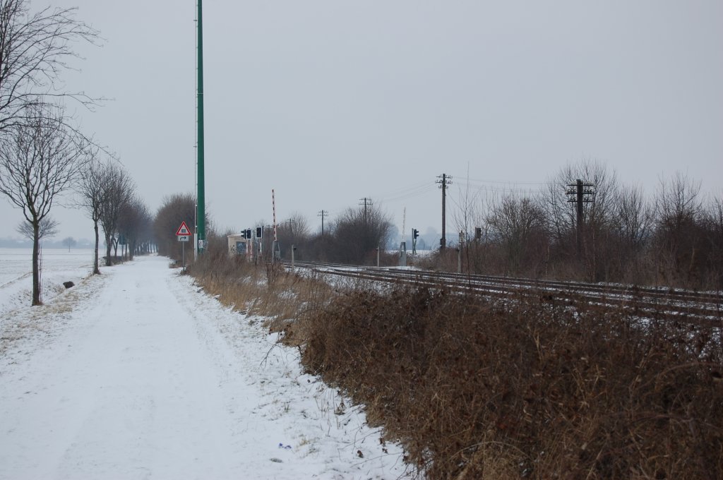 Kurz hinter dem Bahnhof Kapellen in Richtung Neuss kommt einer der zahlreichen Feldwegbahn�berg�nge an der Erftbahn. Besonders sch�n sind die immer noch vorhandenen Telegraphenmasten. Foto vom 13.2.2010