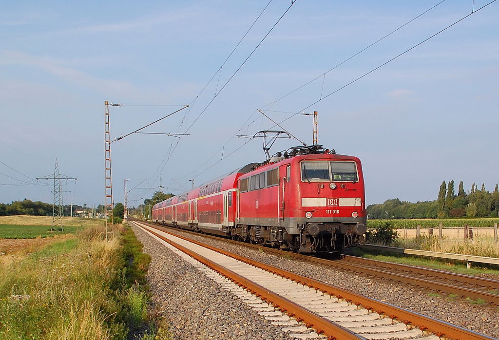 Kurz hinterm Bahnbergang Am Chur in Wickrathhahn ist die  111 016 mit einem RE4 Zug nach Dortmund unterwegs......am Abend des 9.7.2012
