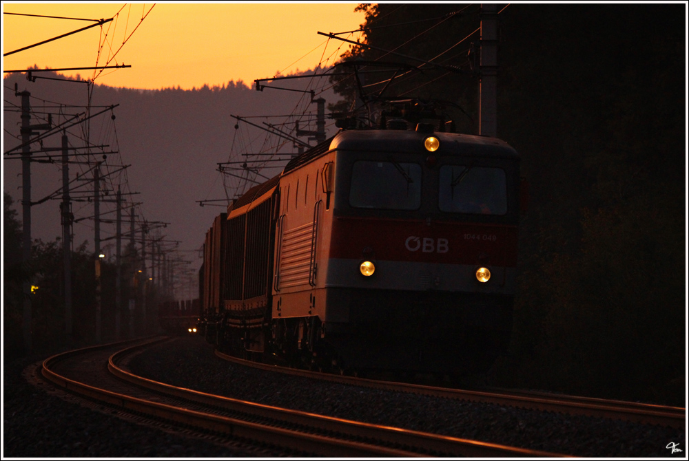 Kurz nach Sonnenuntergang fhrt 1044 049 mit Gterzug 54066 von Bruck Mur nach Wien Zvbf. 
Gloggnitz 18.10.2011