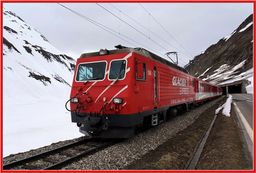 Kurz vor dem Bahnhof Oberalppasshhe kommt der Regionalzug, die HGe 4/4 106 macht nur fr den Glacier Express Werbung, aus dem Tunnel, der die Kantone Uri und Graubnden trennt. Ich stehe in Graubnden am 8.5.2012.