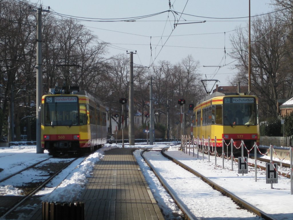Kurzes  Bahnmeeting  am Ettlinger Stadtbahnhof. Whred Tw 577 (Rechts im Bild und bei der Ausfahrt) als S11 nach Hochstetten fhrt und sich warm hlt,  friert  der linke Tw 560 auf einem der vielen Abstellgleise. Tw 560 ist mit einem Luftqualittsmessungsgert ber dem vorderen Zielrollband ausgestattet. Aufnahmedatum: 07.03.2010.