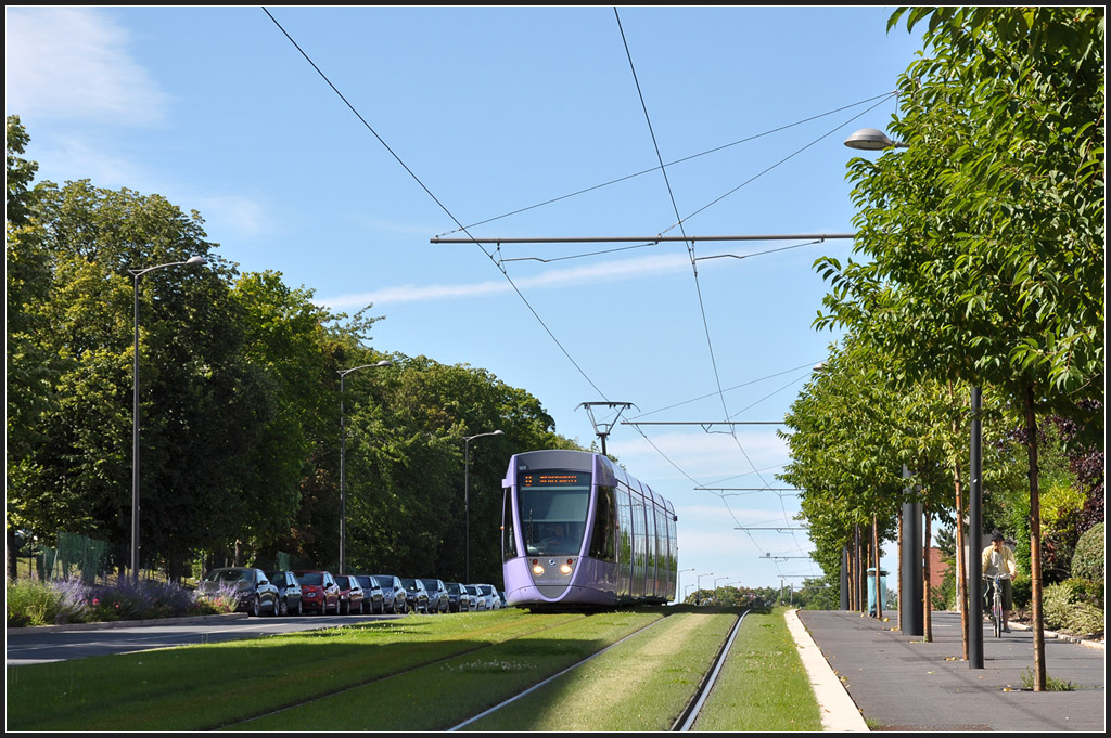Lila Tram auf grüner Trasse - 

Citadis 103 in Fahrtrichtung Innenstadt auf dem Rasenbahnkörper zwischen den Haltestellen  Franchet d'Esperey  und  Courlancy . Die früher vielspurige Avenue du Général de Gaulle wurde mit dem Straßenbahnbau auf zwei Fahrspuren zurückgebaut. 

24.07.2012 (J)