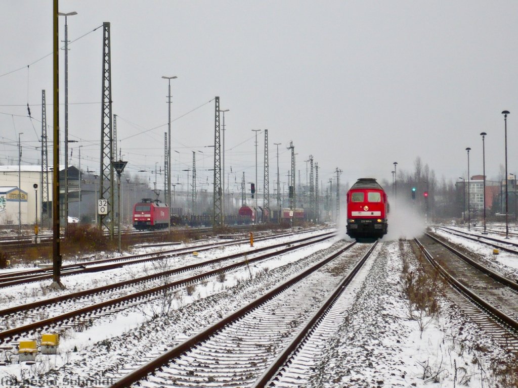 Links durchfährt ein Güterzug den Bahnhof Göschwitz (Saale) in Richtung Saalfeld (Saale), aber rechts (!) kommt Ludmilla 232 569-4 mit einem RE aus Erfurt Hbf in den Bahnhof eingefahren! Dieser Zug fährt bis Altenburg und von dort wieder als RE zurück nach Erfurt Hbf. (19.12.2009)