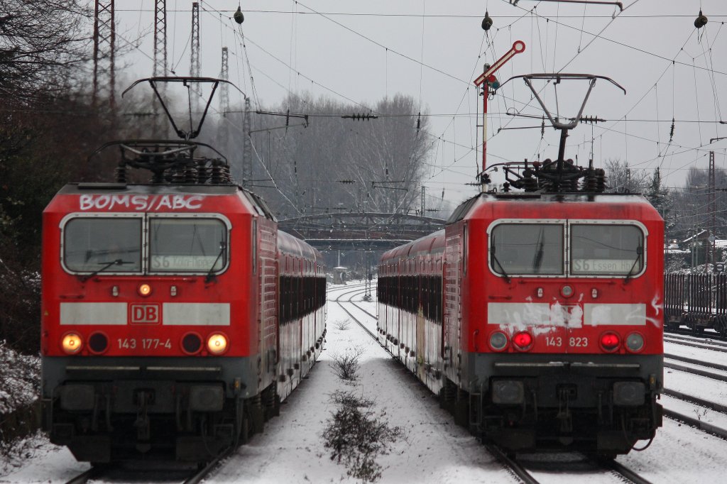 Links fhrt 143 177 in Krze mit einer S6 nach Kln-Nippes in den Bahnhof Dsseldorf-Rath ein.
Rechts schiebt 143 823 eine leicht versptete S6 nach Essen Hbf in Richtungen Ratingen.
Aufgenommen am 6.2.13.