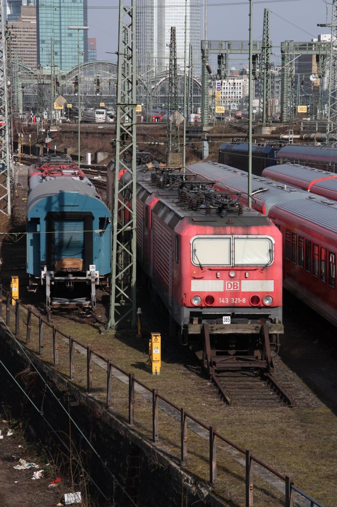 Links(Gleis 386) steht ein dreiachsiger Umbauwagen und rechts (Gleis 385) die z-gestellte 143 321 mit ihren Schwesterloks.Am 19.03.10 in Frankfurt(Main).
