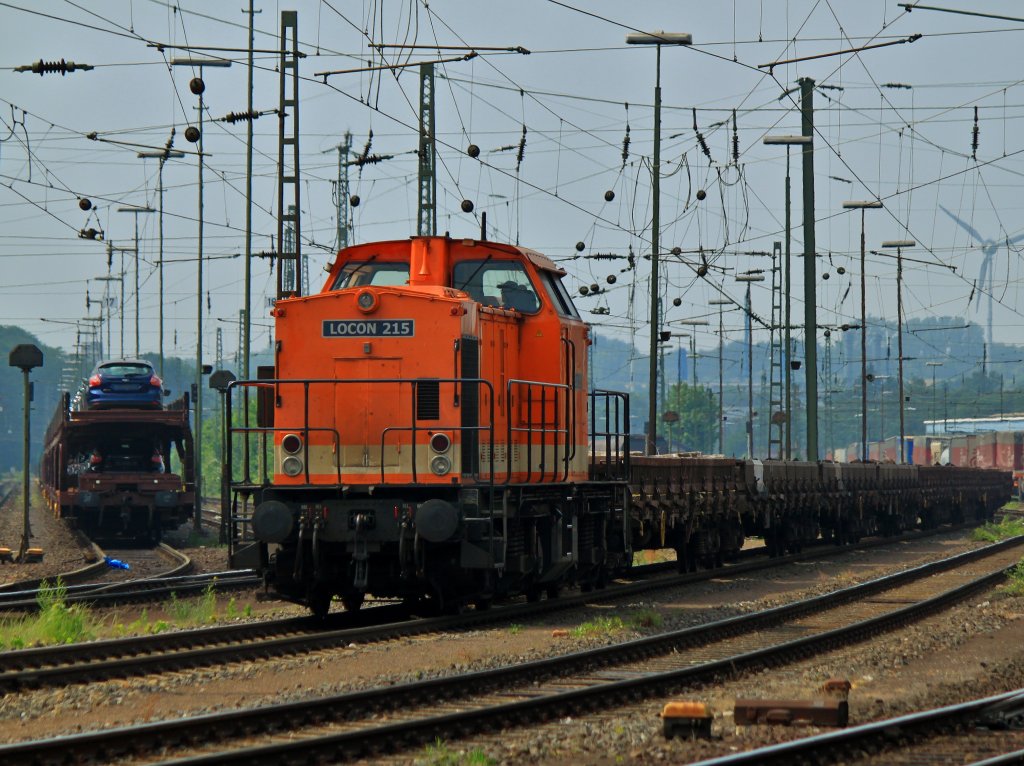 Locon 215 (203 141-7) steht am 30.05.2012 mit einem mit alten Holzschwellen beladenen Flachwagenzug in Aachen West.