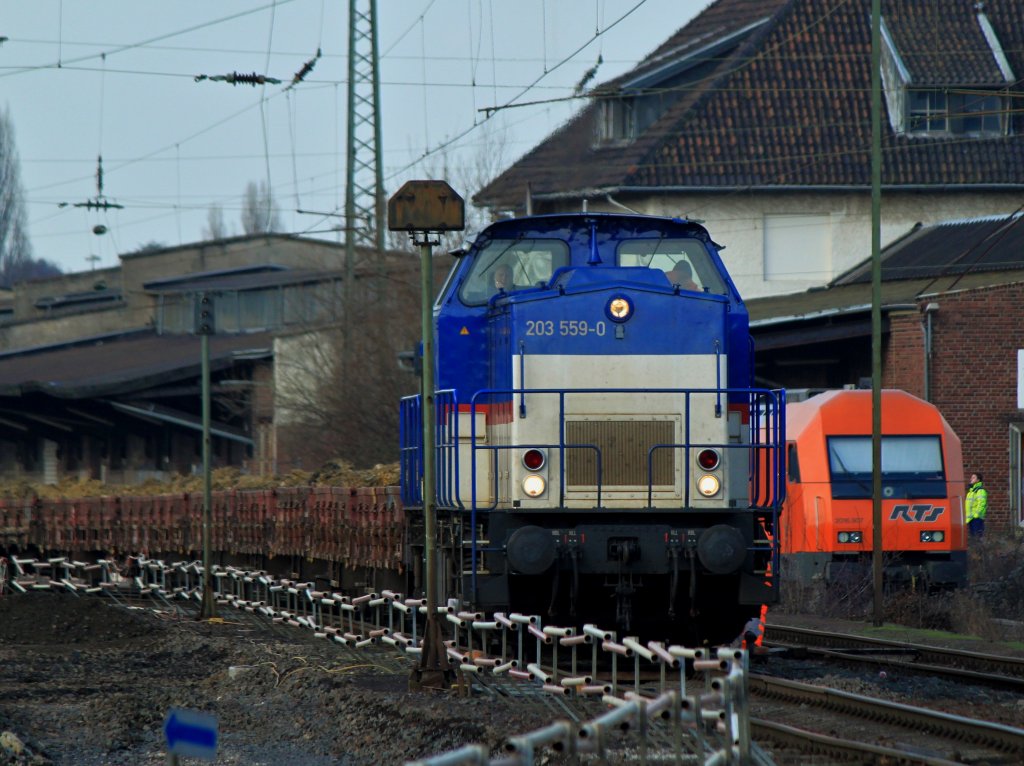 Locon 219 (203 559-0) verlt am 11.01.2013 mit einem mit Abraum beladenen Niederbordwagenzug die Baustelle in Aachen West nach Stolberg. Rechts im Bild steht 2016.907 von RTS, die am 27.03.2013 in Obereggendorf (Niedersterreich) auf einen Messzug aufgefahren ist.