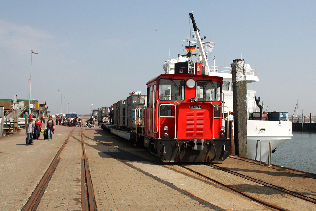 Lok 399 108-0 der Schiffdienst und Inselbahn Wangerooge hat die Flachwagen mit den Gepäck-Containern zur Verladung auf die Fähre  Harlingerland  bereitgestellt. 23.04.2011