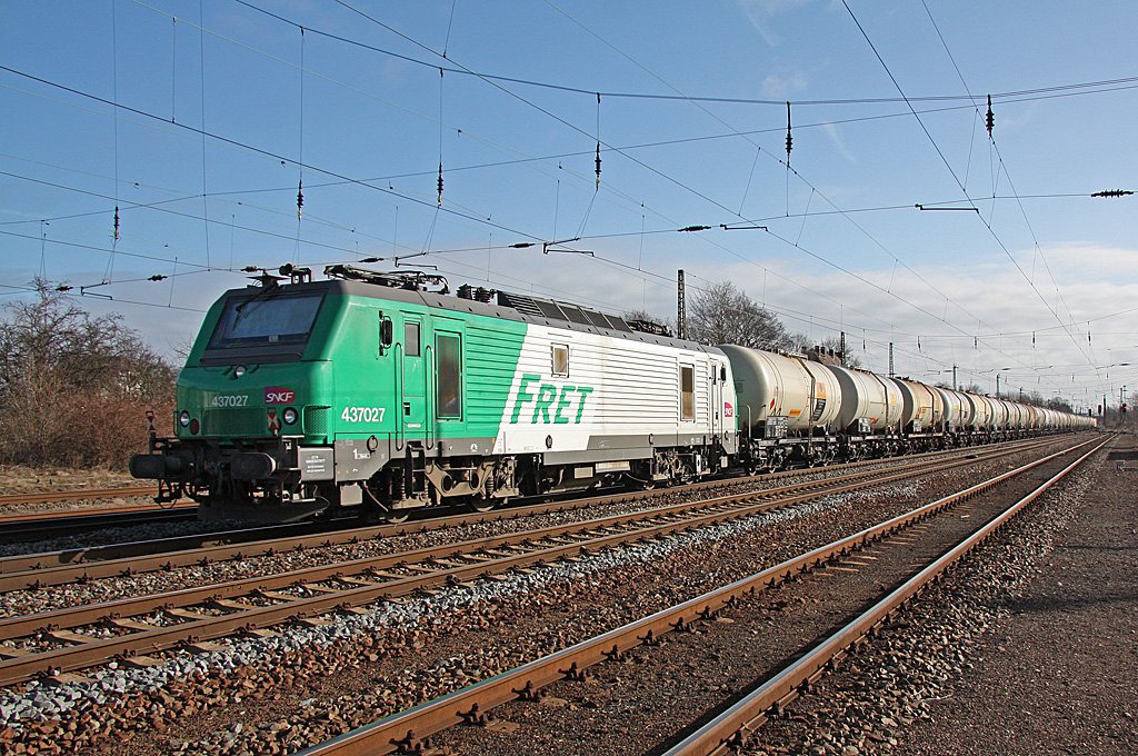 Lok 437 027 der SNCF-Tochter FRET hngt(kalt)am Zugschlu eines Kesselwagenzuges der hier am Morgen des 15.03.2010 den Bahnhof Leipzig-Wiederitzsch durchfhrt.