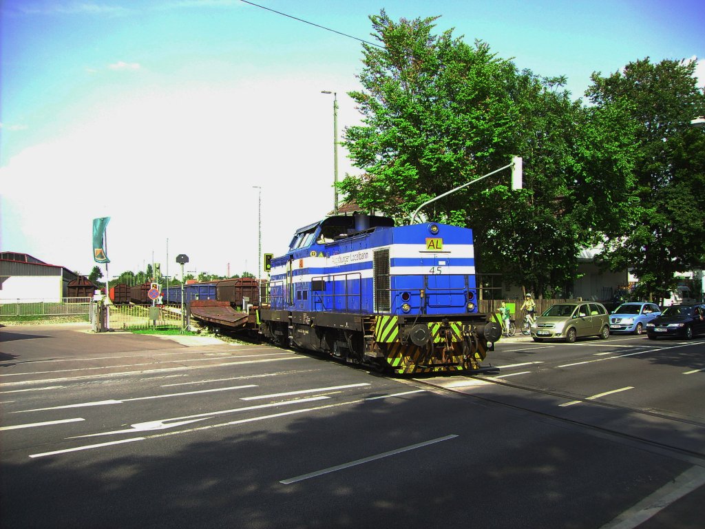 Lok 45 der Augsburger Localbahn (AL) passiert am 10.08.2012 die stark befahrene Friedberger Strae (B 300) um ihren Eaos-Zug in Richtung Augsburg Hauptbahnhof zu ziehen. Vielen Dank fr die Abfahrtszeit an die Lokleitung der AL!