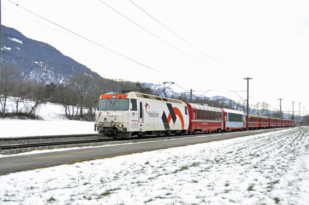 Lok 649 der Rhb von Typ Ge 4'4 III auf den Namen Lavin getauft mit Werbung fr Holcim unterwegs.Der Zug passiert Felsberg bei Chur am 29.1.2013 mit RE 1140 aus St.Moritz.