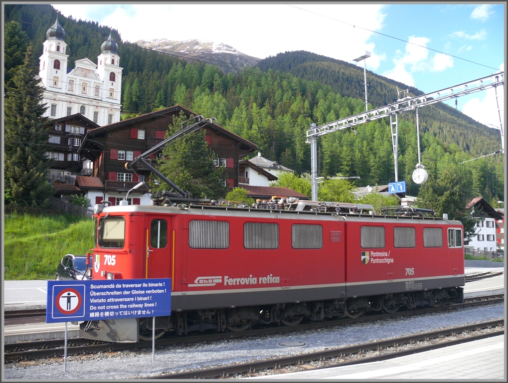 Lok 705 vor den Trmen des Klosters Disentis wird zwar etwas verdeckt, aber das Schild verdient doch auch seine Beachtung, wurde doch hier die zweite Landessprache der Schweiz kurzerhand durch asiatische Schriftzeichen ersetzt. (27.05.2010)