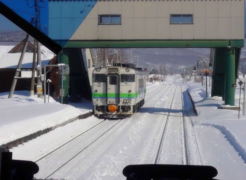 Lokalverkehr in Ost-Hokkaido: Nur wenige Menschen benutzen die kleinen Zwischenstationen an der nördlichen der beiden Ost-West-Transversalen auf der Insel Hokkaido. In ruhiger Umgebung wartet KIHA 40 712 in Ikaushi die Kreuzung ab, 17.Februar 2009. (Aufnahme durch die verglaste Führerstandrückwand eines Gegenzugs)  SEKIHOKU-LINIE