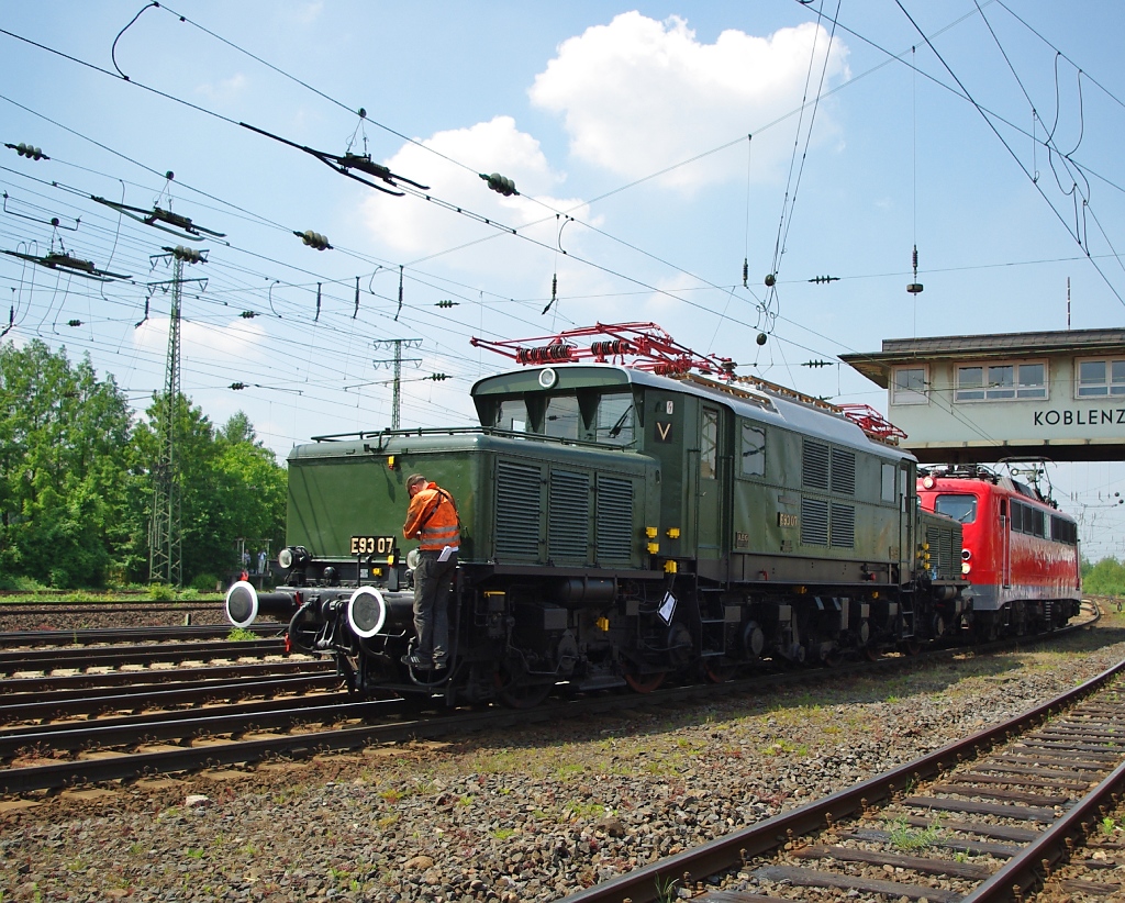 Lokparade im DB Museum Koblenz-Ltzel am 21.05.2011 zu dessen 10 jhrigen Bestehen. E 93 07 und 115 152-1.  Die schwere Gterzug-Lokomotive E93 07 ist eine Besucherin aus Baden Wrttemberg. Sie verbrachte ihr ganzes Leben damit Gterzge, manchmal auch Reisezge, ber die 22 Promille Rampe, die Geislinger Steige, von Kornwestheim nach Ulm zu bringen. Dafr brachte die bei AEG gebaute Lok eine Leistung von 3400 PS mit.  40 Jahre war sie bis zu ihrer Ausmusterung  im Dienst. Geschoben wird sie von der 115 152-1 welche am 04.02.1957 als erste Serienlok der Baureihe 110 als E10 152 in Mnchen in Dienst gestellt wurde. Nach 50 Jahren Dienstzeit wurde sie im Dezember 2006  Z-gestellt.  Am 01.01.2007  wurde sie von der DB Autozug GmbH  fr den Einsatz vor Auto- und Nachtzgen gekauft. Nach weiteren 200.000 Kilometern und einer Gesamtfahrleistung  von 9.000.000(!) Laufkilometern wurde sie im Juni 2009 endgltig Z-gestellt und dem Verein Baureihe E10 e.V. als Dauerleihgabe bergeben. 