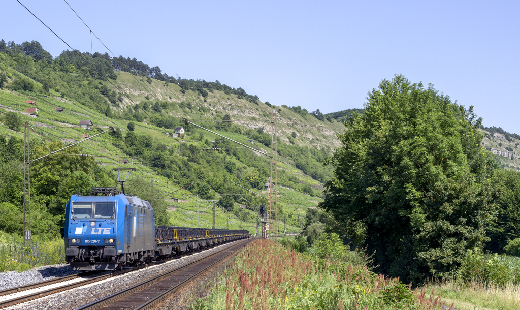 LTE 185 528-7 f�hrt mit einem Flachwagenzug durch das Maintal, hier bei Harrbach (07.07.2013)