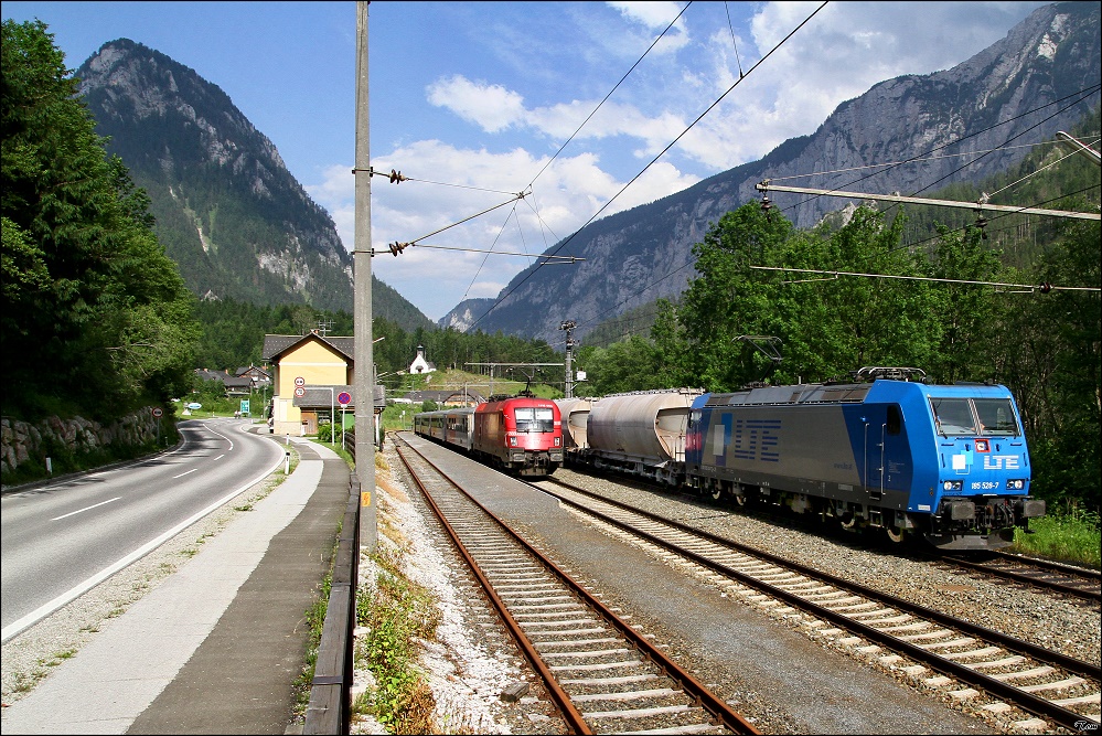 LTE 185 528 Kaolinzug fhrt mit SGAG 48983 von Passau nach Gratkorn, whrend 1116 003  Rail Cargo Austria  mit Rex 3295  Nationalpark Gesuse  von Schladming nach Wien West im Bahnhof Gstatterboden auf die Weiterfahrt wartet. 12.6.2010