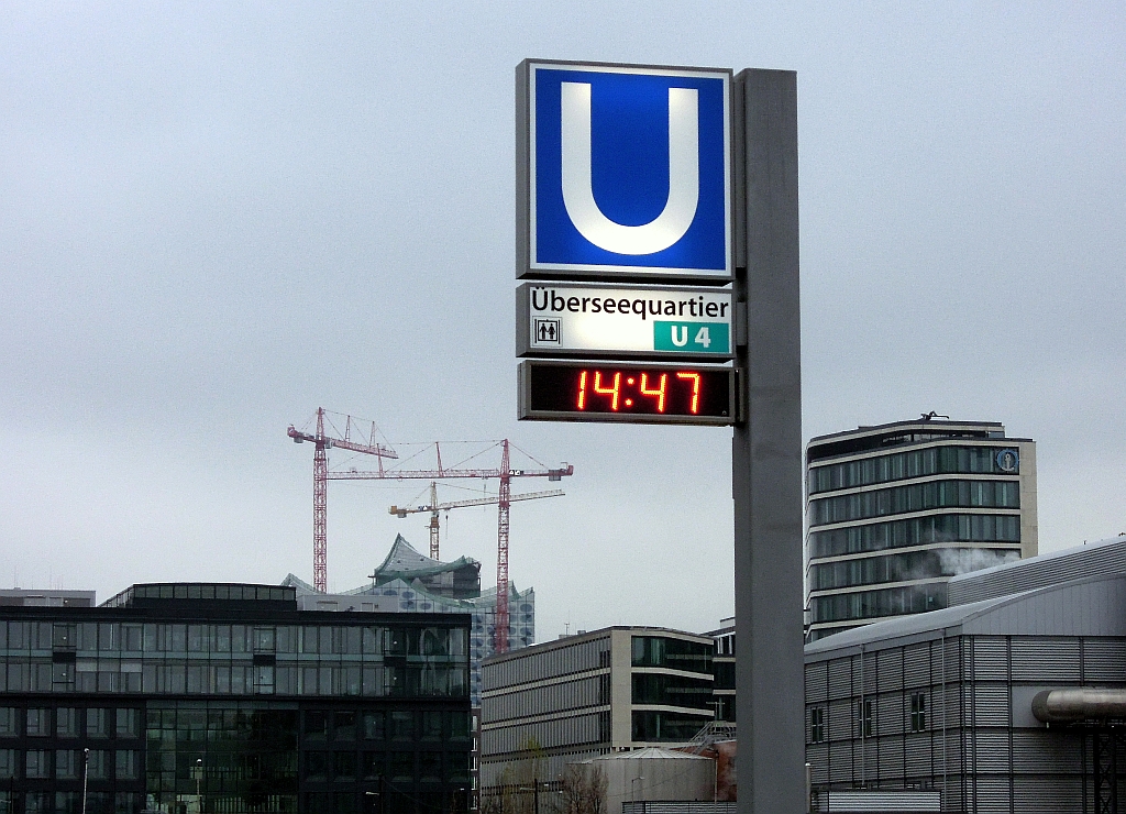Man kann das U-Bahn Signet der Haltestelle  berseequartier  auch so fotografieren, als befnde sich der Ausgang zumindest in der Umgebung eines stdtebaulichen Ambientes. Die Baustelle der umstrittenen Elbphilharmonie im Hintergrund verweist allerdings auf das Provisorische oberhalb der neuen Hamburger U-Bahnlinie U4. 2.12.2012