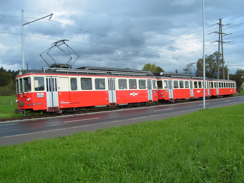 Mein Bild Nummer 1500 widme ich den BDe 4/4-Pendezgen der Forchbahn. Nach ihrer Ausmusterung wurden sie nach Madagaskar verschifft, in der Hoffnung, dass sie dort nach dem Einbau eines Dieselmotors weitere verkehren wrden. Wie sich heute zeigt, ist dies unmglich, denn es existieren zwar Schienen, aber die sind nicht befahrbar. Und so verrosten diese einst so stolzen Zge weit weg von ihrer Heimat. Auf dem Bild zu sehen ist der BDe 4/4 12, der gemeinsam mit dem BDe 4/4 13 und dem Bt 105 bei ihrer Abschiedsfahrt einen Fotohalt einlegt. Emmat, 17.10.2004.