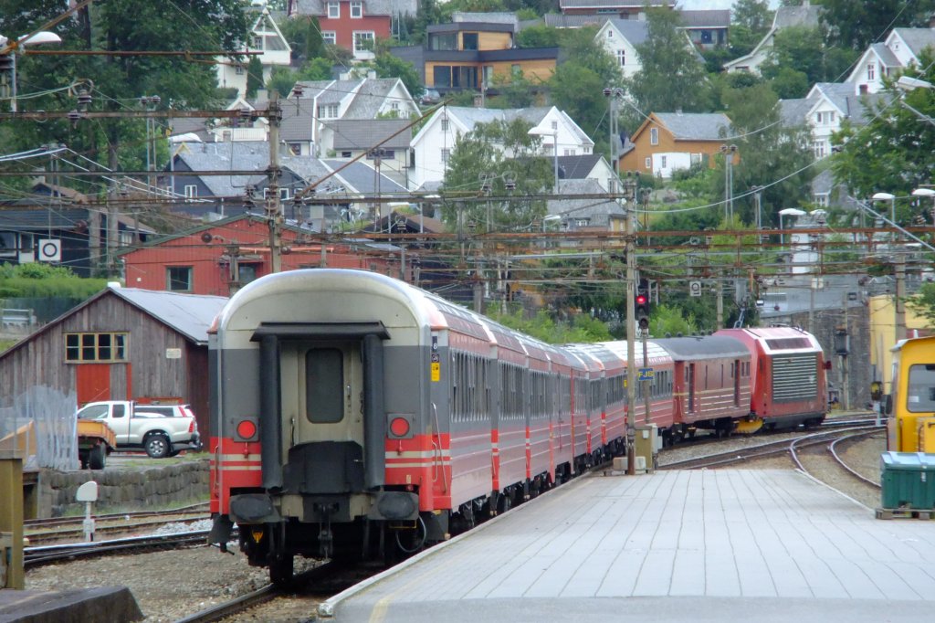 Mein  Lieblingszug  609 (Bergen - Oslo) besteht ausschliesslich aus Altbauwagen der Typen 3 und 5. Mit einer El 18 an der Spitze verlsst dieser vor allem als Ausflugszug (mit Velowagen, ohne 1. Klasse) gedachte Zug am 6.7.2010 den Bahnhof Voss und nimmt die Steigung Richtung Myrdal und Finse in Angriff. 