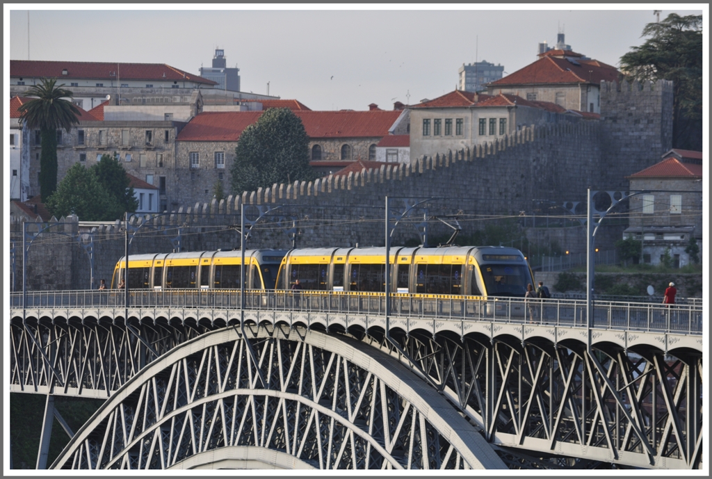 Metro do Porto. Vor einem Teil der Stadtmauer von Porto hat eine Doppeleinheit der Metro die Brckenmitte erreicht. (14.05.2011)