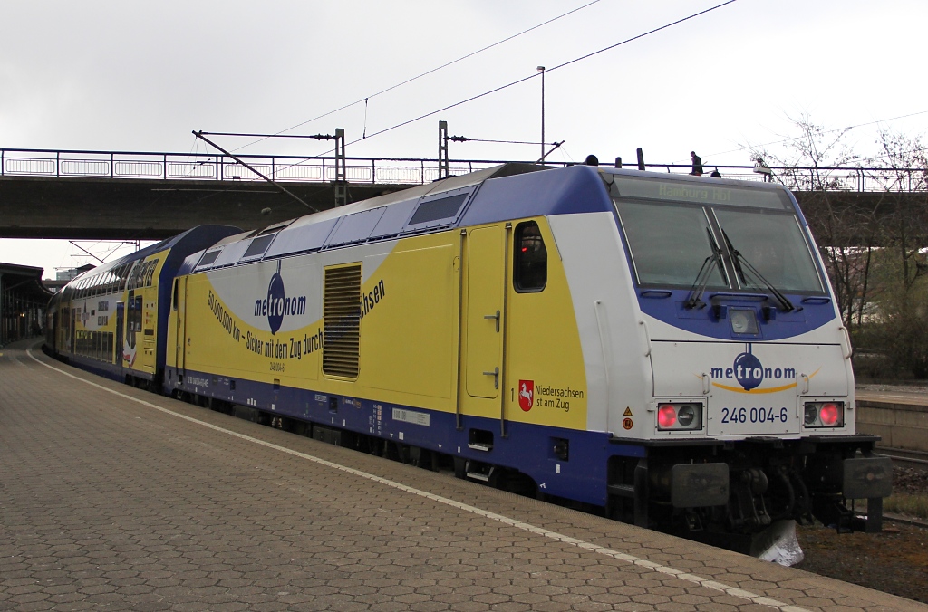Metronom von Cuxhaven nach Hamburg Hbf beim Halt in Hamburg-Harburg. Bespannt mit 246 004-6 mit der  50.000.000 km - Sicher mit dem Zug durch Niedersachsen -Werbung und einem Herbert Gr�nemeyer Wagen. Aufgenommen am 12.04.2012.