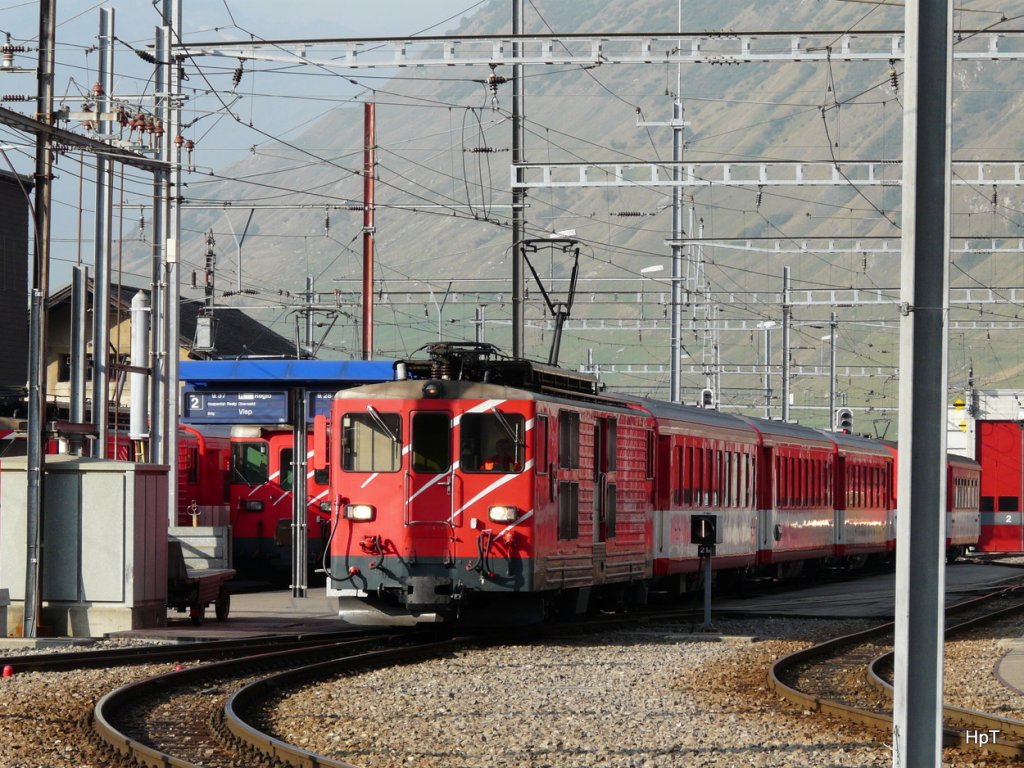 MGB - Im Bahnhof Andermatt ist der Triebwagen Deh 4/4 91 vor einem Regio nach Gschen am 25.09.2009