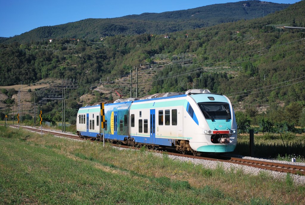 Minuetto-Triebwagen der LFI auf der Hhe von Baciano (Zug Stia-Arezzo), August 2011. Hinten ragen die Alpe di Catenaia.