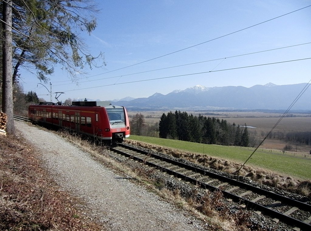 Mit Blick auf das Murnauer Moos und die bayerischen Alpen ist 426 029-5 am 07.03.2012 als RB 59566 von Oberammergau nach Murnau zwischen den Haltepunkten Grafenaschau und Seeleiten-Berggeist unterwegs.