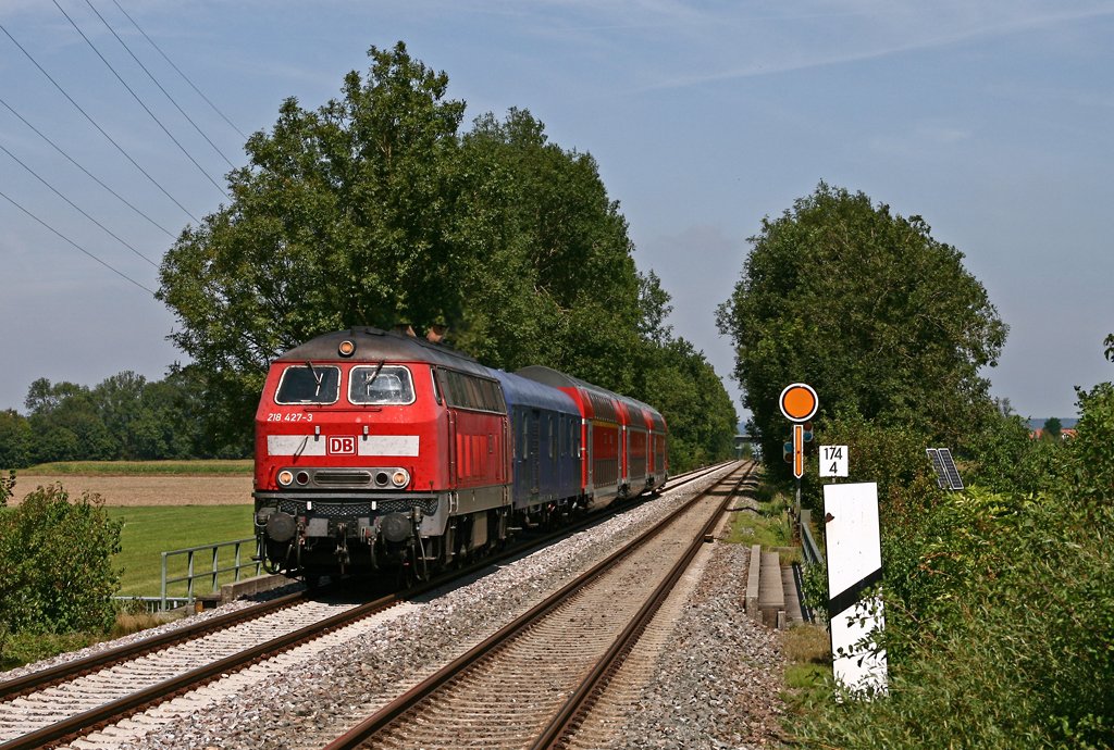 Mit dem IRE 4209 von Ulm nach Lindau ist die Ulmer 218 427 am 23. August 2009 bei Weingarten/Berg unterwegs. Direkt hinter der Lok ist bei diesem Zug ein ehemaliger CNL-Wagen als Fahrradwagen eingereiht.